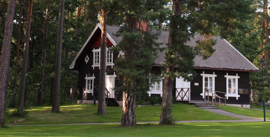 Acksjöns kapell, en stugliknande träbyggnad, syns mellan tallarna.