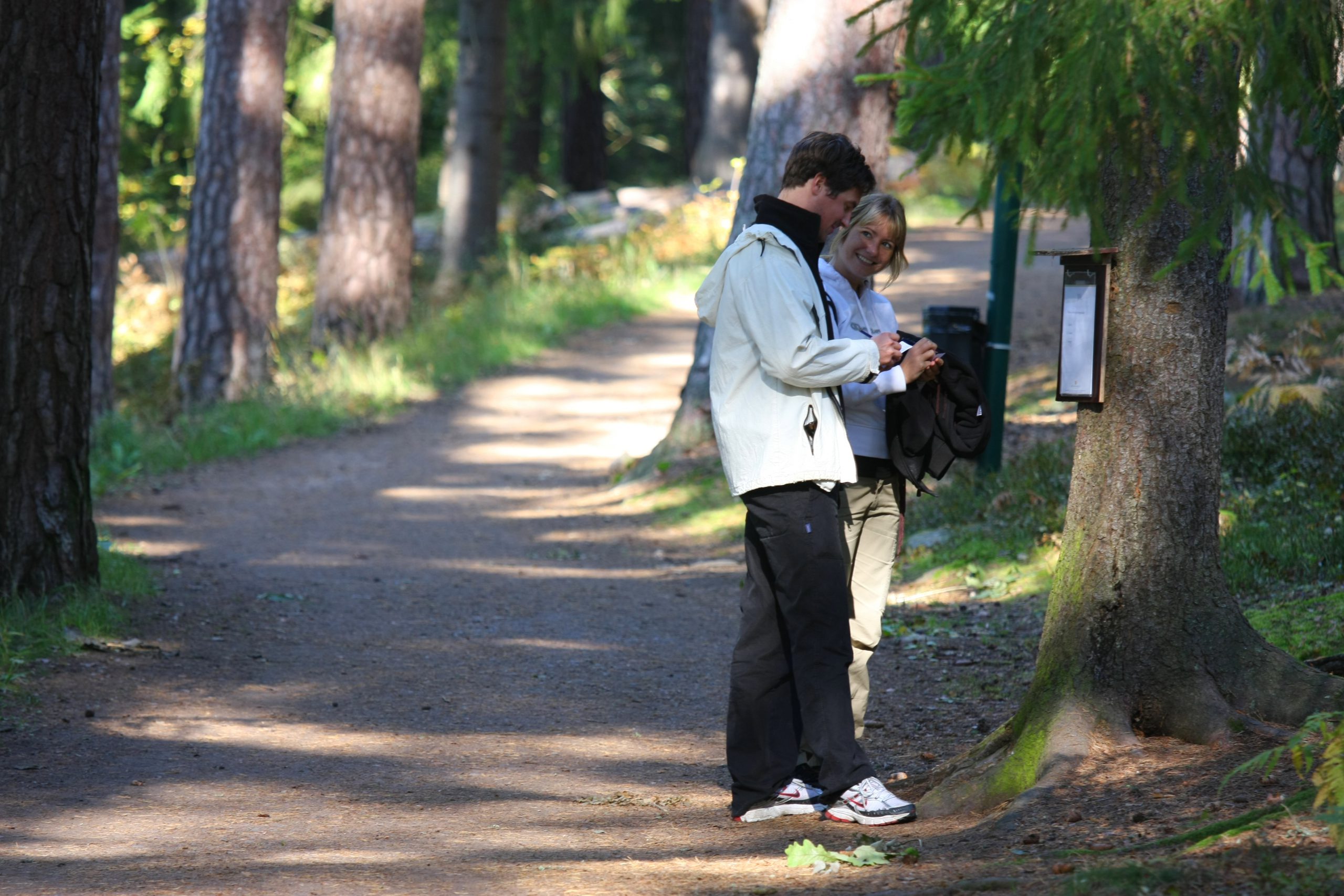 En man och kvinna på tipspromenad i skogen.