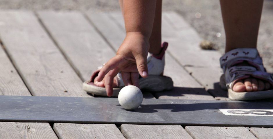 Närbild på en barnhand som sträcker sig efter en bangolfboll.