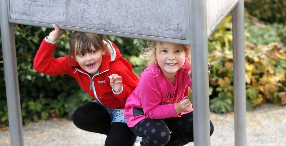 Två flickor leker glatt i Lekträdgården.